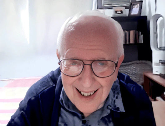 Smiling elderly man with glasses in a home setting, featured on The Edward Gorey Online Shop.