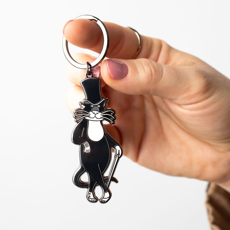 Hand holding Bustopher Jones cat keychain from The Edward Gorey Online Shop