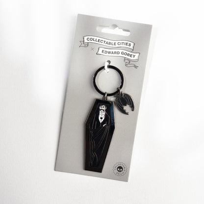 Edward Gorey Dracula coffin keychain with bat charm on branded card packaging
