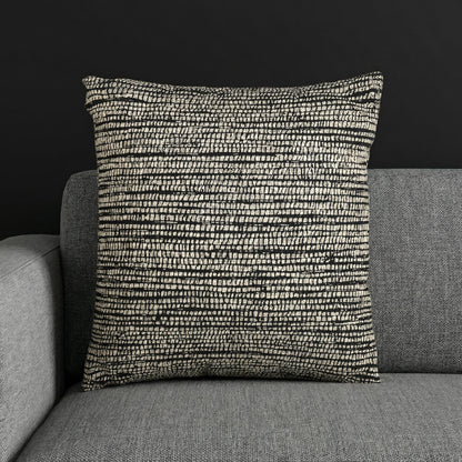 Woven textured cushion with black and cream pattern on a gray sofa, Edward Gorey shop decor
