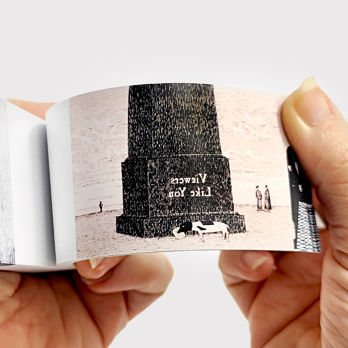 Hands flipping through Edward Gorey flipbook, dark monument, cows, and figures illustrated