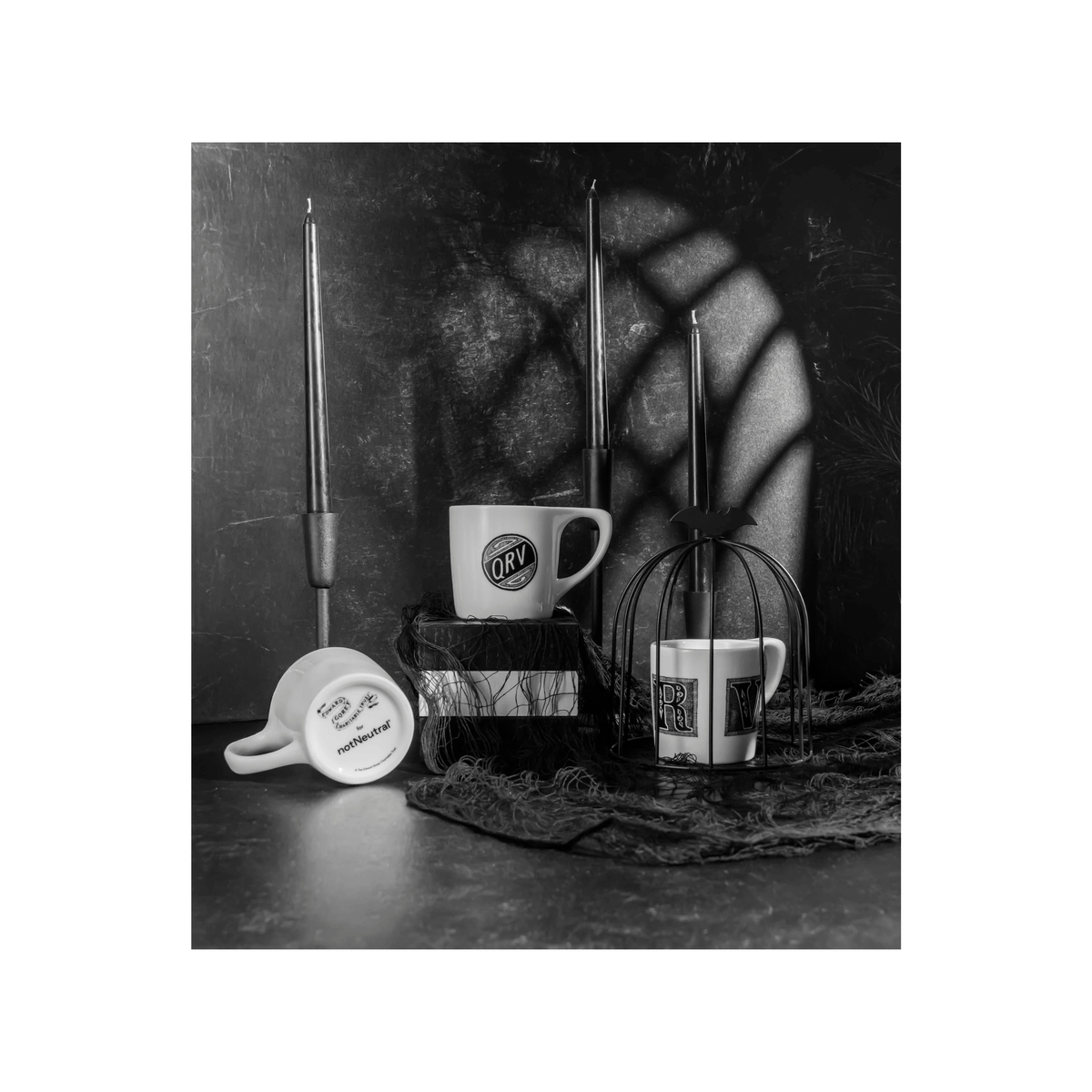 Edward Gorey Q-R-V Humanity mug set with gothic candles and bat decor, black and white.