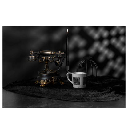 Edward Gorey Q-R-V Reality mug on dark table with vintage phone and black candle